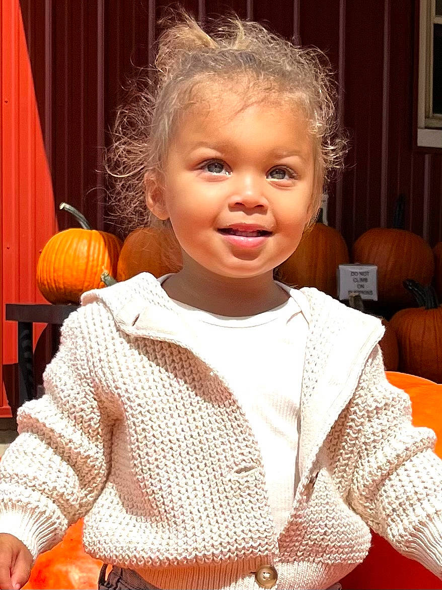 Sunny is registered to the contest to win money with this photo: baby_toddler_clothing, calabaza, cheek, child, cucurbita, curtain, dress, facial_expression, flooring, gourd, hairstyle, happy, orange, person, plant, pumpkin, sleeve, smile, toddler, vegetable