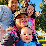 Santiago joined the competition — help win amazing prizes! baby, casual_clothing, child, daylight, family, glasses, group, happy, hat, man, nature, outdoor, park, people, portrait, selfie, smile, sunlight, tree, woman