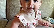 Love joined the competition — help win amazing prizes! baby, child, infant, cute, pink_bow, floral_outfit, couch, beige, indoors, portrait, sitting, curious, rosy_cheeks, skin, small_hands, small_feet, face, eyes, hair, person