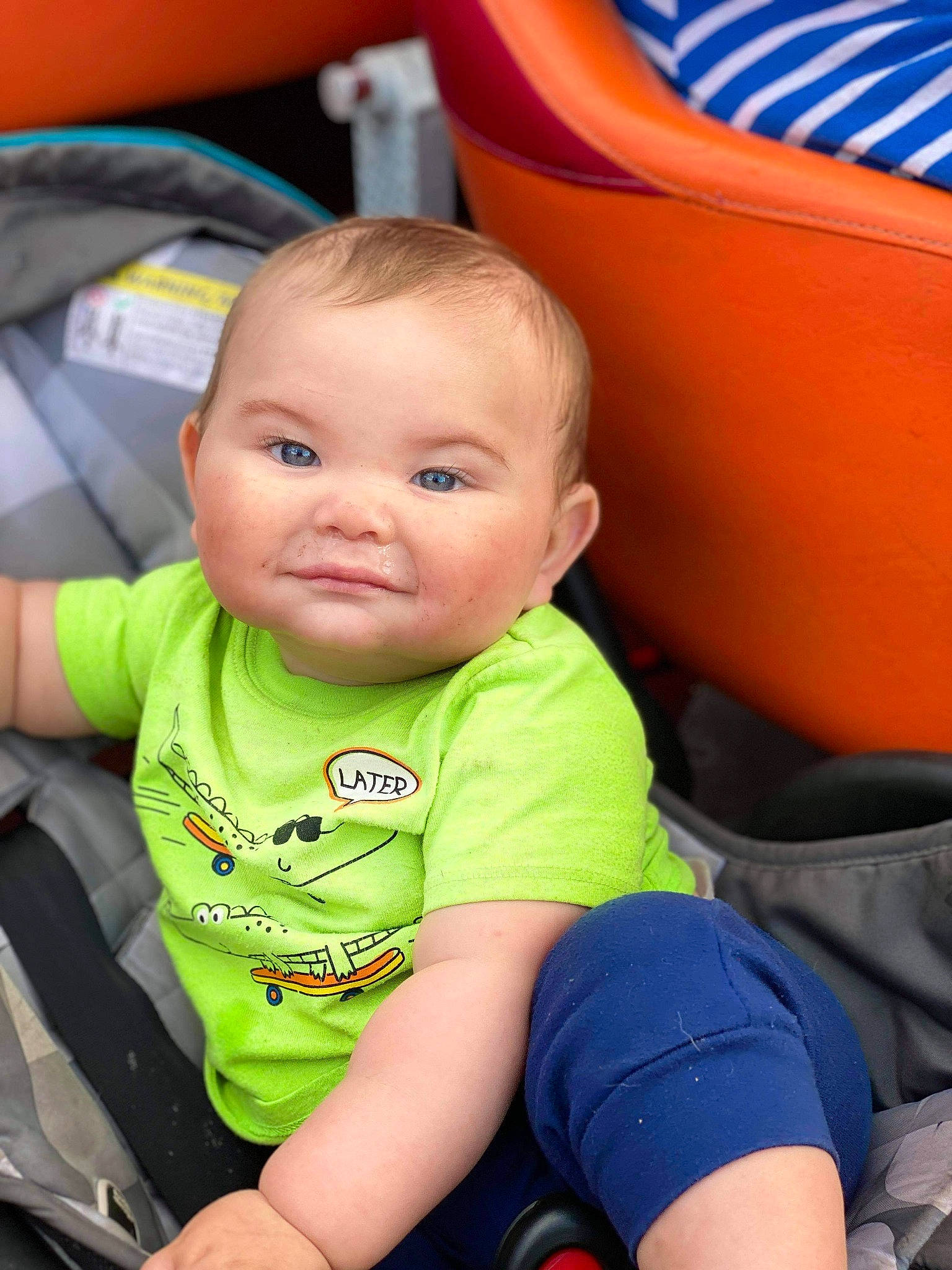 James is registered to the contest to win money with this photo: auto_part, baby, baby_toddler_clothing, blue, cheek, child, chin, comfort, face, fun, hairstyle, happy, head, leisure, person, sitting, skin, sleeve, smile, toddler