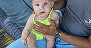 Miller Grace joined the competition — help win amazing prizes! adult, baby, blue_eyes, blue_jeans, brick_wall, child, expression, footwear, gray_tshirt, green_outfit, hand, holding, outdoor, person, porch, sitting, sock, swing, watch, wooden_floor