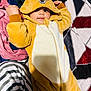 baby, blanket, child, clothing, colorful, costume, cozy, cute, deer, face, hand, hood, indoors, lying_down, onesie, playful, plush, smile, soft_texture, striped_pants
