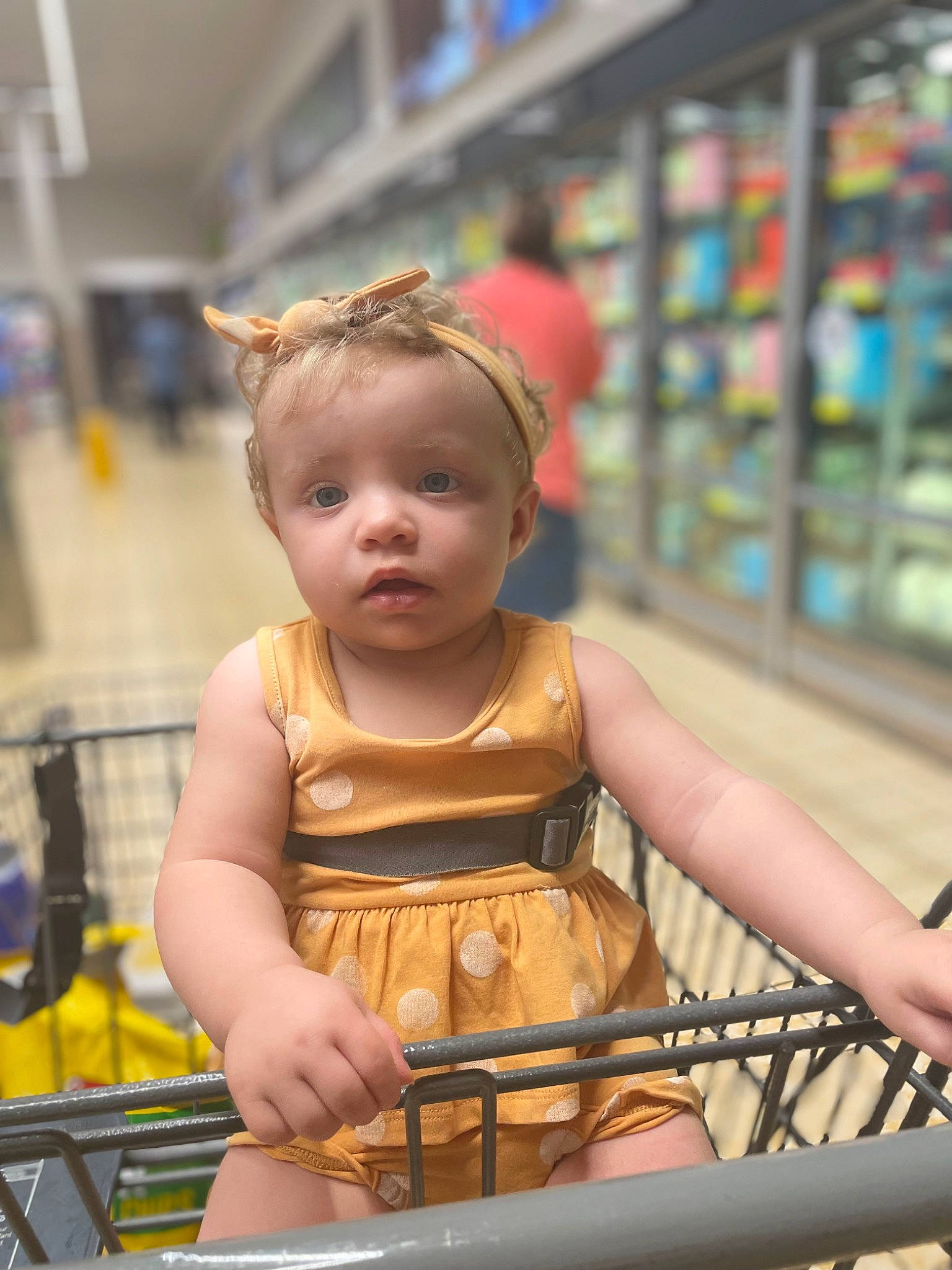 Maddison is registered to the contest to win money with this photo: baby, baby_toddler_clothing, child, customer, fashion_design, fun, happy, leisure, metal, person, recreation, retail, shelf, shelving, shopping_cart, sitting, toddler