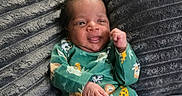 Klins is registered to the contest to win money with this photo: newborn, baby, infant, child, portrait, lying_down, smiling, face, fist, hand, green_outfit, animal_print, onesie, blanket, fuzzy_blanket, indoor, close_up, awake, cute, photography