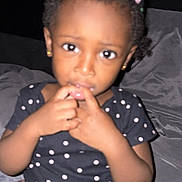 Daria joined the competition — help win amazing prizes! child, girl, toddler, portrait, sitting, bed, bedroom, polka_dot, dress, hair_clips, braids, earrings, dark_skin, curious, looking_at_camera, hands, indoor, flash_photography, candid, home