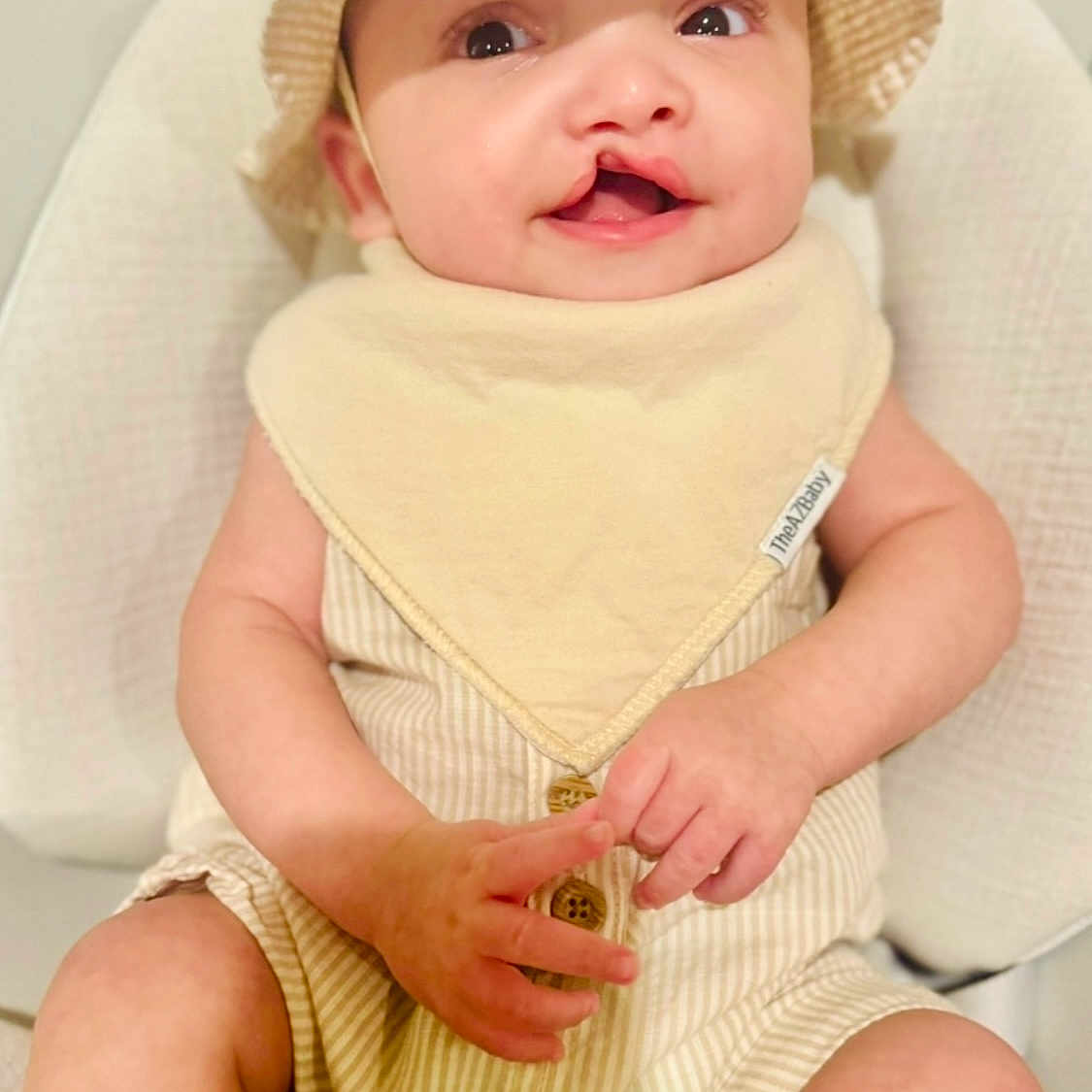 Roa is registered to the contest to win money with this photo: baby, bodypart, bonnet, bottle, cap, clothing, cosmetics, face, finger, hand, happy, hat, head, newborn, perfume, person, photography, portrait, sitting, sunhat