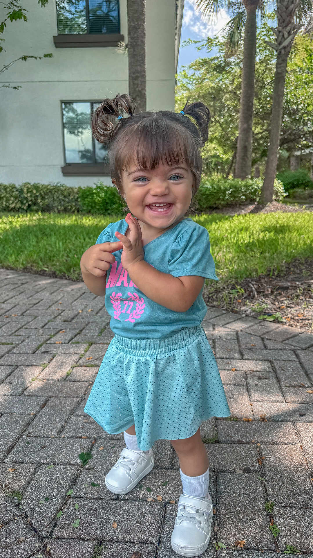 Bella joined the competition — help win amazing prizes! child, toddler, smiling, outdoor, pigtails, blue_clothing, white_shoes, grass, tree, sidewalk, sunlight, happy, person, cute, portrait, young_child, nature, daylight, building, casual_wear