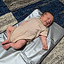 Jace is registered to the contest to win money with this photo: baby, newborn, infant, smile, sleeping, carpet, changing_mat, clothing, striped, skin, foot, hand, indoor, floor, cute, peaceful, baby_boy, soft, relaxing, happy