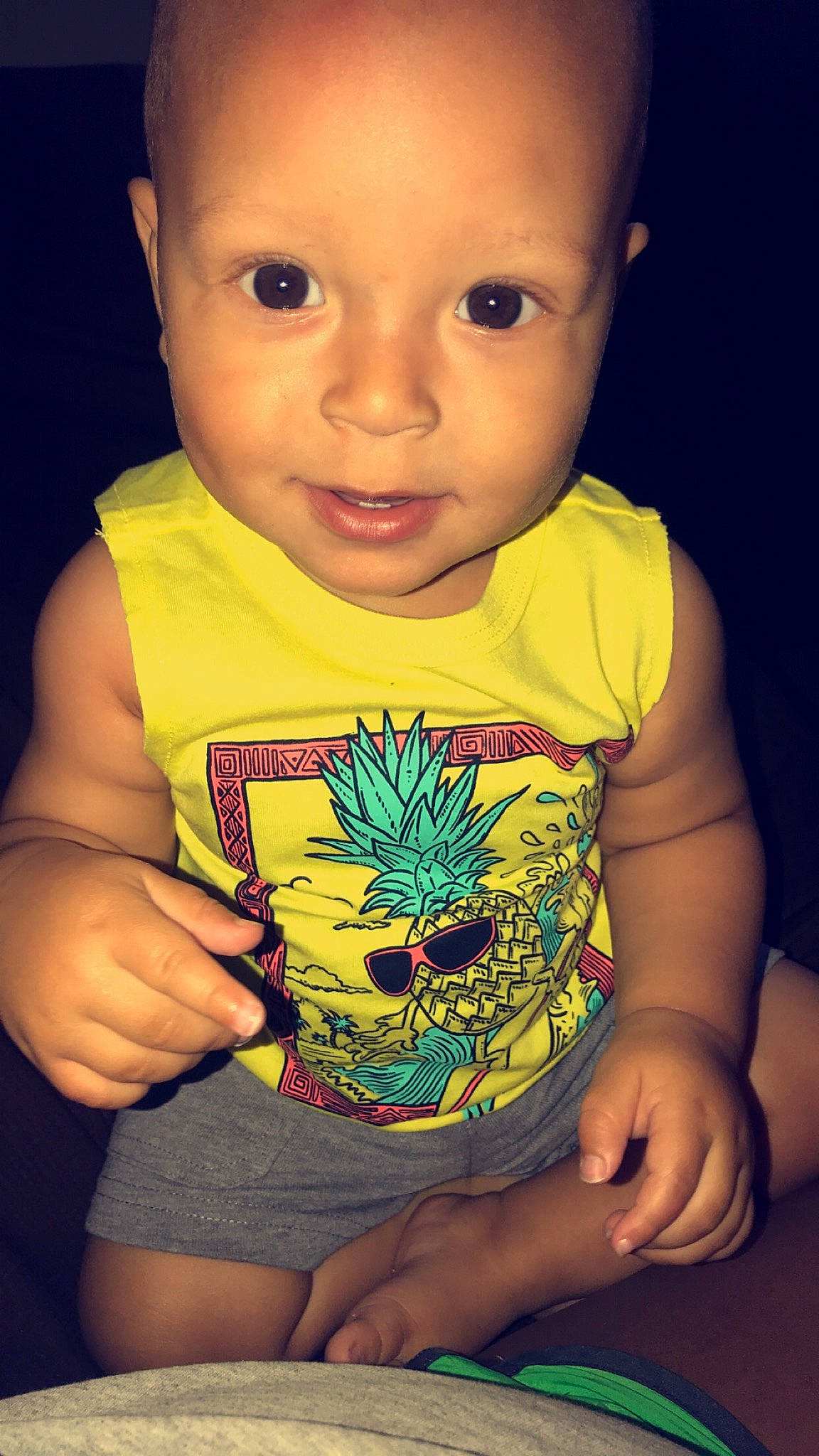 Madden is registered to the contest to win money with this photo: arm, baby, cheek, child, face, facial_expression, finger, fun, hand, head, mouth, person, plant, play, smile, thumb, toddler, top, yellow