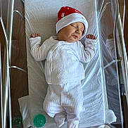 Tristan joined the competition — help win amazing prizes! baby, newborn, sleeping, hospital, bassinet, white_clothing, red_hat, pacifier, blanket, infant, cute, peaceful, resting, indoors, person, bed, footed_pajamas, sleep, child, healthcare