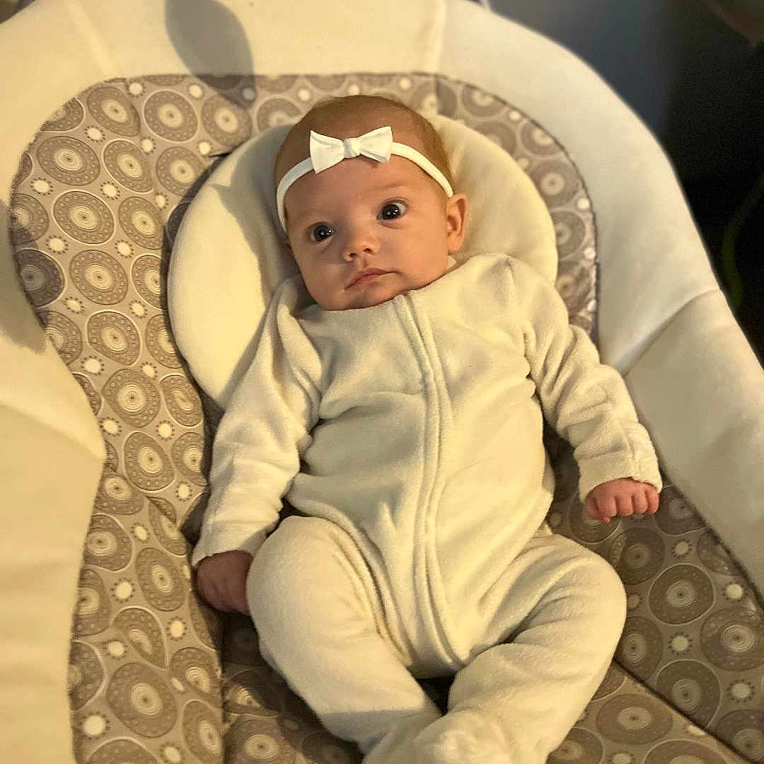 Stormi joined the competition — help win amazing prizes! baby, baby_products, baby_toddler_clothing, chair, cheek, child, circle, comfort, eye, hairstyle, human_body, linens, pattern, room, sitting, sleeve, toddler