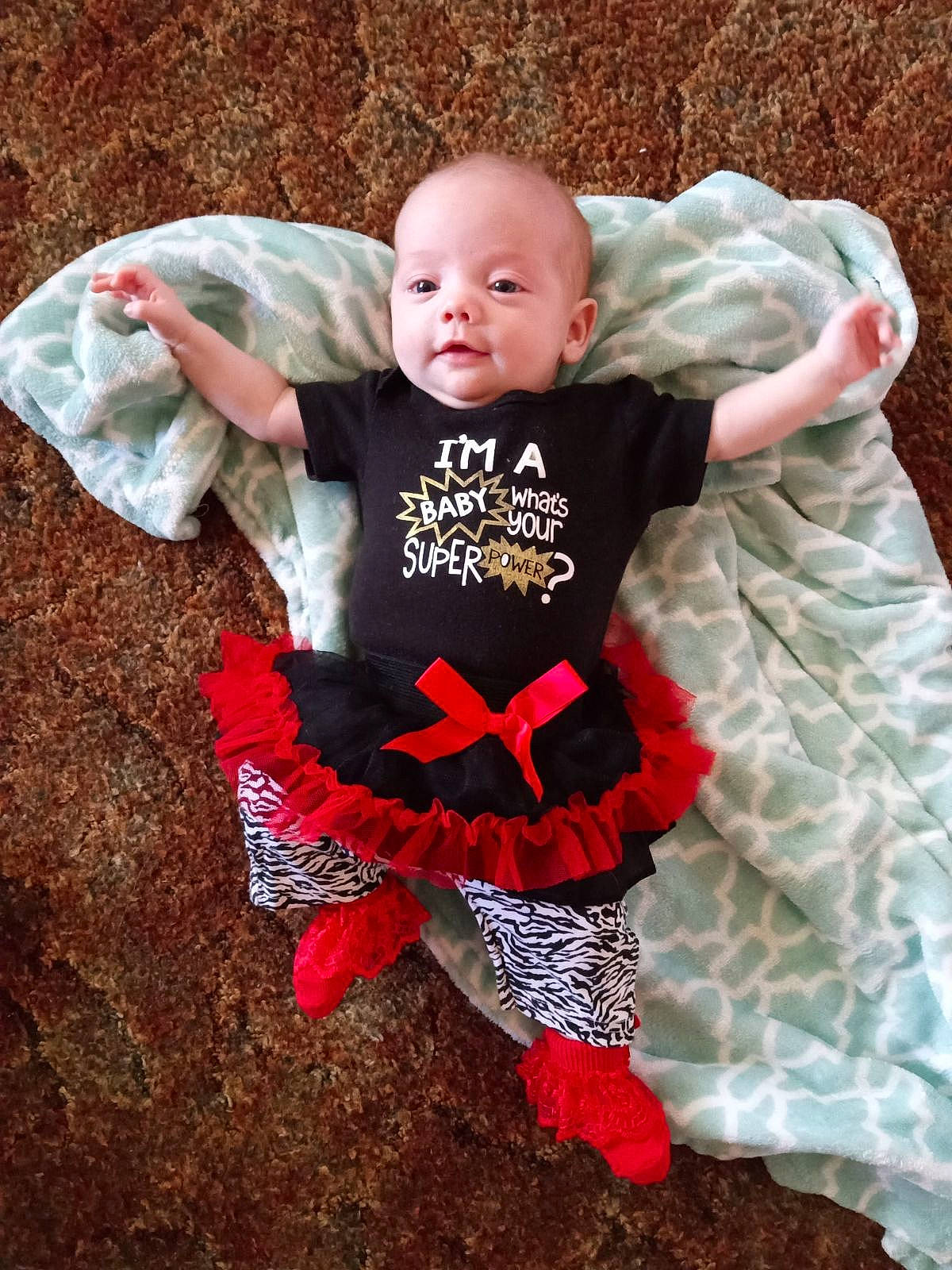 Stormi is registered to the contest to win money with this photo: baby, baby_toddler_clothing, child, comfort, eye, face, flash_photography, fun, grass, happy, head, human_body, linens, pattern, person, pink, sitting, sleeve, smile, t_shirt