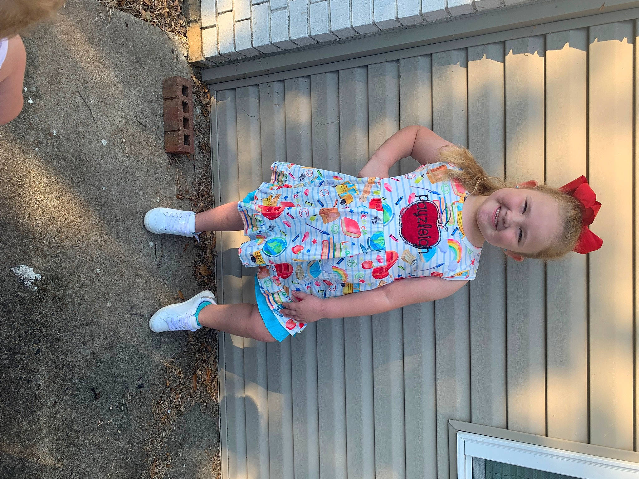 Payzleigh is registered to the contest to win money with this photo: baby_toddler_clothing, child, electric_blue, fashion, fence, fun, happy, human_leg, joy, leisure, magenta, pattern, person, pink, sandal, sitting, t_shirt, textile, thigh, toddler