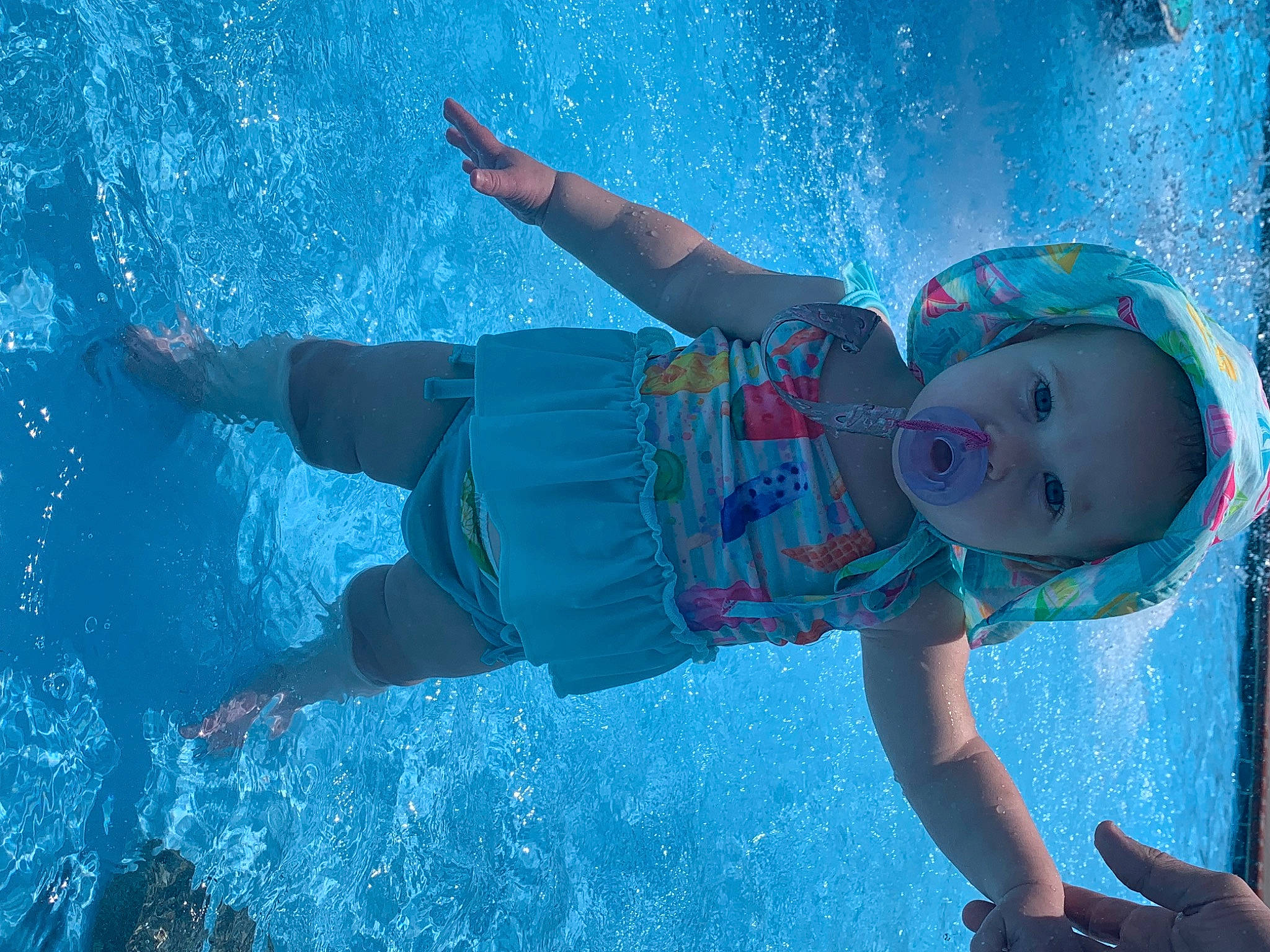 Bryleigh is registered to the contest to win money with this photo: aqua, azure, baby, body_of_water, child, electric_blue, fun, happy, hat, leisure, outdoor_recreation, person, personal_protective_equipment, play, recreation, swimming_pool, toddler, underwater, vacation, water
