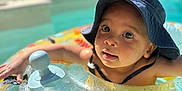 Issa a rejoint le concours — aidez-le/la à gagner de superbes lots ! child, toddler, inflatable_ring, pool, water, sun_hat, summer, outdoor, swimming, float, baby, sunlight, vacation, recreation, fun, playful, skin, face, cute, leisure
