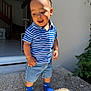 toddler, child, boy, blue_shirt, striped_shirt, denim_shorts, blue_socks, outdoor, doorway, sunlight, smiling, happy, standing, casual_clothing, home_interior, plants, stairs, floor, portrait, playful