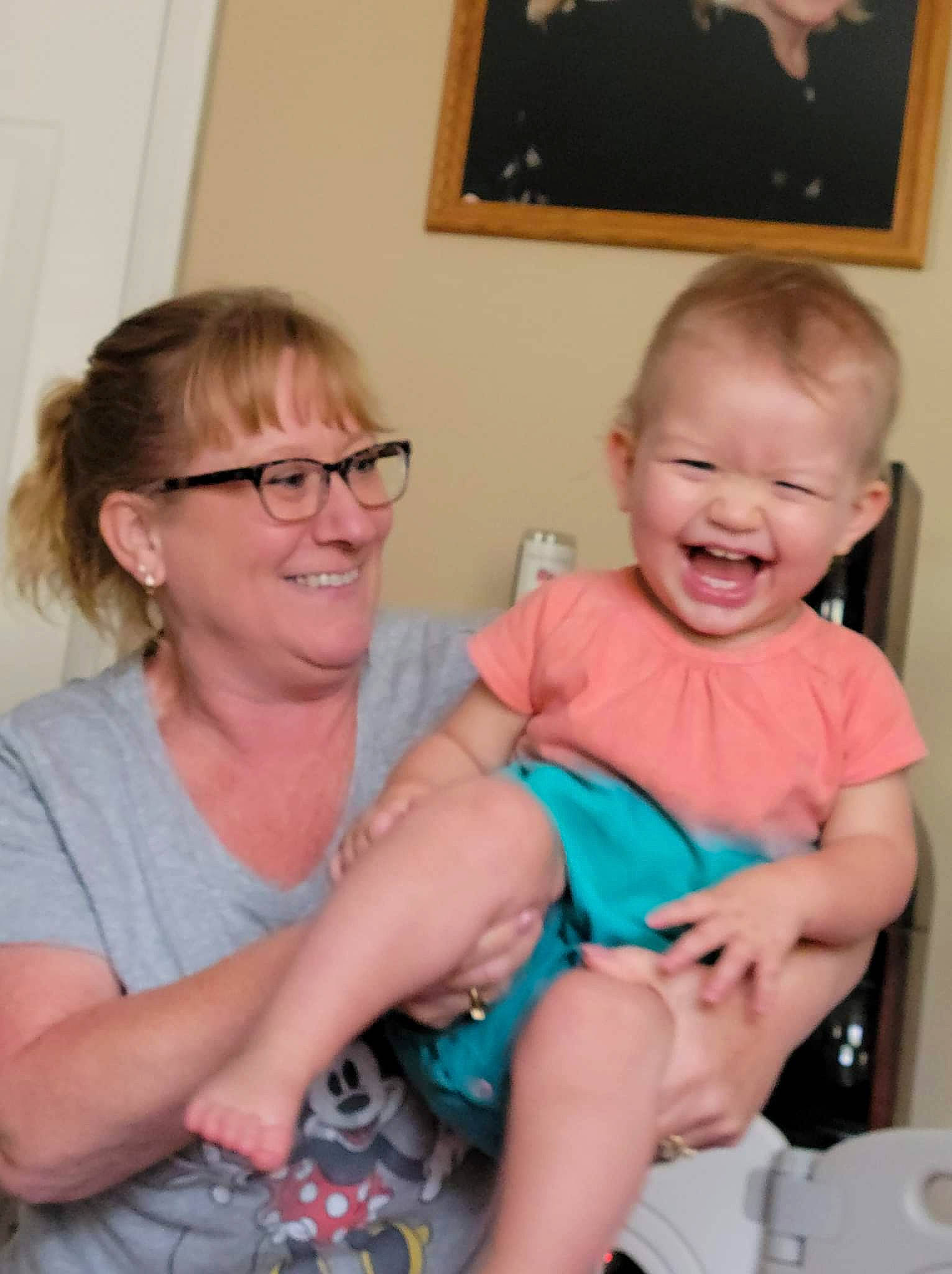 Harper is registered to the contest to win money with this photo: baby_toddler_clothing, child, comfort, couch, event, facial_expression, finger, fun, glasses, happy, iris, joy, lap, mouth, organ, person, picture_frame, shoulder, sitting, skin