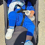 Lorenzo a rejoint le concours — aidez-le/la à gagner de superbes lots ! toddler, child, sleeping, stroller, blue_clothing, baby_bottle, blanket, white_shoes, outdoor, sunlight, sidewalk, casual, resting, baby, footwear, person, young_child, relaxed, daytime, cute