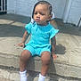 toddler, child, braids, beads, white_socks, turquoise_outfit, sitting, concrete_step, outdoor, sunny, toy_ring, portrait, casual_clothing, young_child, daylight, sidewalk, expression, person, hair_style, baby