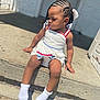 toddler, child, braids, white_beads, dress, socks, concrete, step, outdoor, sunlight, curious, sitting, hair, person, young_child, side_view, shadow, toy, casual, daylight