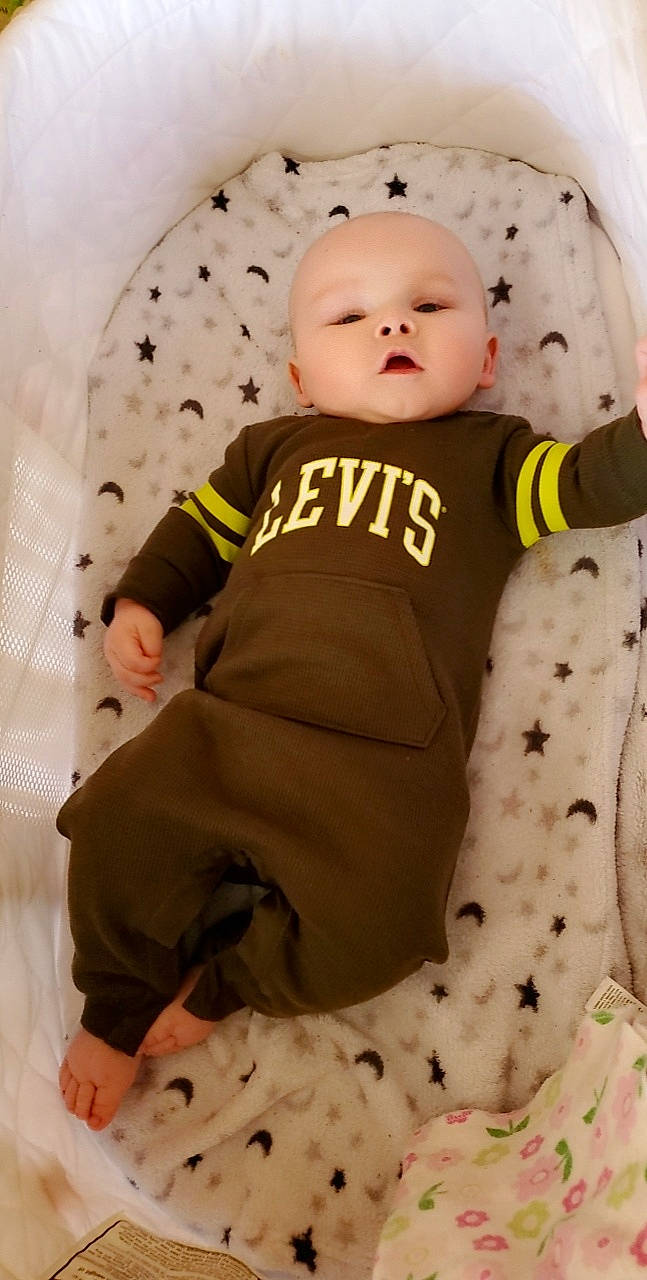 Ryker is registered to the contest to win money with this photo: baby, baby_products, baby_safety, baby_toddler_clothing, baby_toys, cheek, child, comfort, fur, headgear, linens, outerwear, pattern, person, pink, sitting, skin, sleeve, t_shirt, toddler