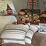 dog, small_dog, couch, pillows, striped_pillows, halloween_pillow, pumpkin, scarecrow, fall_decor, thanksgiving_decor, indoor, cozy, decorations, fabric, cute, pet, orange_harness, sitting, home, holiday