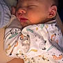 Taylor is registered to the contest to win money with this photo: baby, sleeping, infant, onesie, animal_print, closeup, face, peaceful, cute, child, soft_lighting, young, portrait, skin, hand, ear, head, cozy, rest, newborn