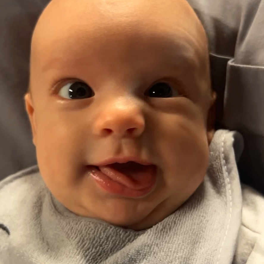 Taylor joined the competition — help win amazing prizes! baby, bib, child, close_up, clothing, cute, expression, eyes, face, happy, head, indoors, infant, mouth, person, portrait, skin, smile, tongue, tongue_out