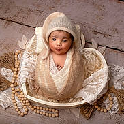 Aarav joined the competition — help win amazing prizes! adorable, baby, basket, blanket, brown_skin, cozy, cute, decorative, expression, headwear, indoors, infant, knit_hat, lace, newborn, portrait, pout, soft_texture, wooden_beads, wrapped