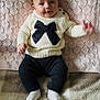 baby, infant, sweater, bow, knitwear, pants, socks, blanket, texture, soft, cute, smile, face, hand, indoor, person, portrait, child, seated, cozy