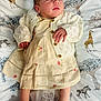newborn, baby, sleeping, dress, cardigan, blanket, giraffe, zebra, animal_print, pattern, infant, cute, peaceful, soft_lighting, portrait, child, clothing, fabric, resting, indoors