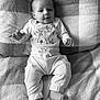 baby, infant, blanket, clothing, striped_shirt, deer_illustration, pants, socks, face, hands, lying_down, soft_texture, cozy, cute, portrait, child, monochrome, black_and_white, indoor, comfortable