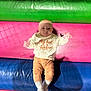 Emmylou joined the competition — help win amazing prizes! baby, child, infant, colorful_background, padded_mats, sweatshirt, orange_pants, white_socks, lying_down, curious_expression, indoor, soft_texture, play_area, cute, young_child, head, face, hand, footwear, clothing