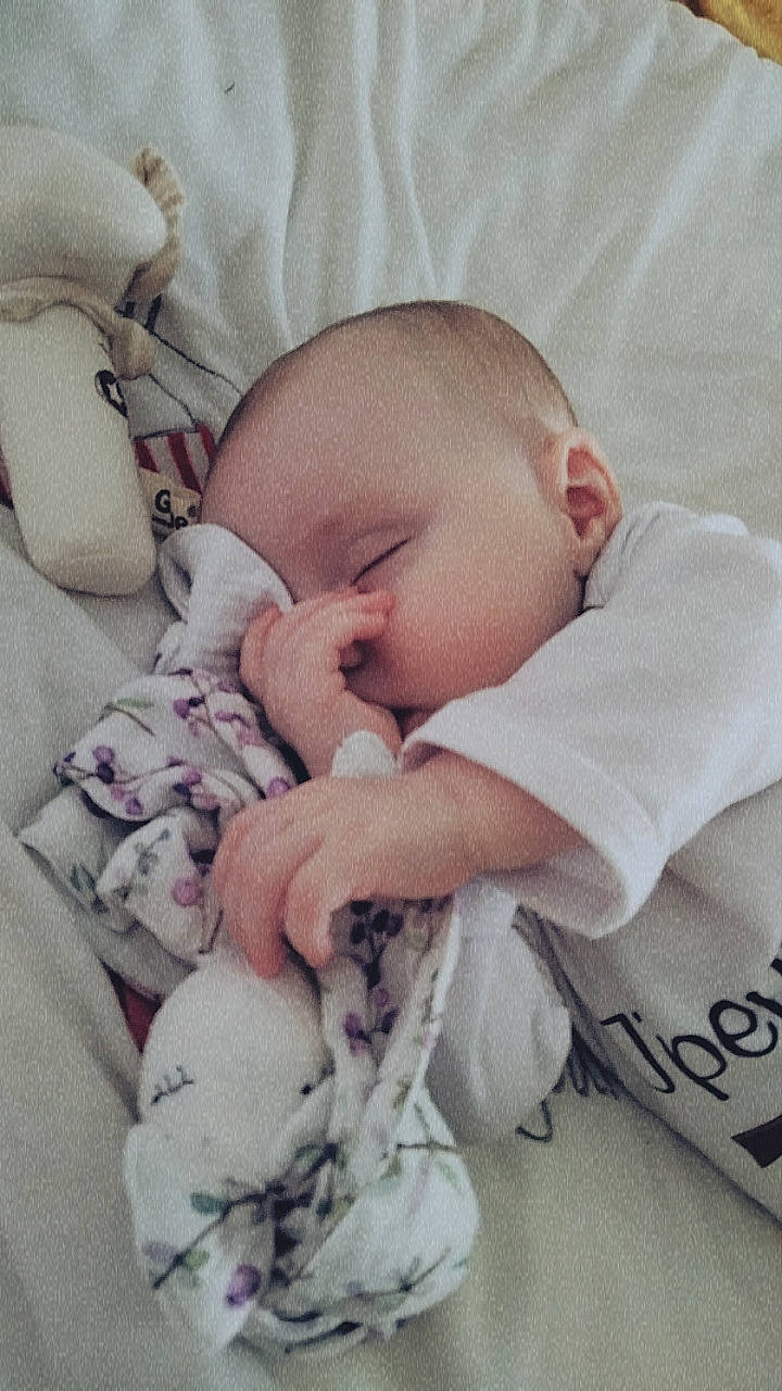 Lyana participe au concours pour gagner de l'argent avec cette photo : baby, baby_products, baby_sleeping, baby_toddler_clothing, cheek, comfort, ear, eye, face, hand, happy, linens, mammal, mouth, nose, person, product, skin, sleeve, textile