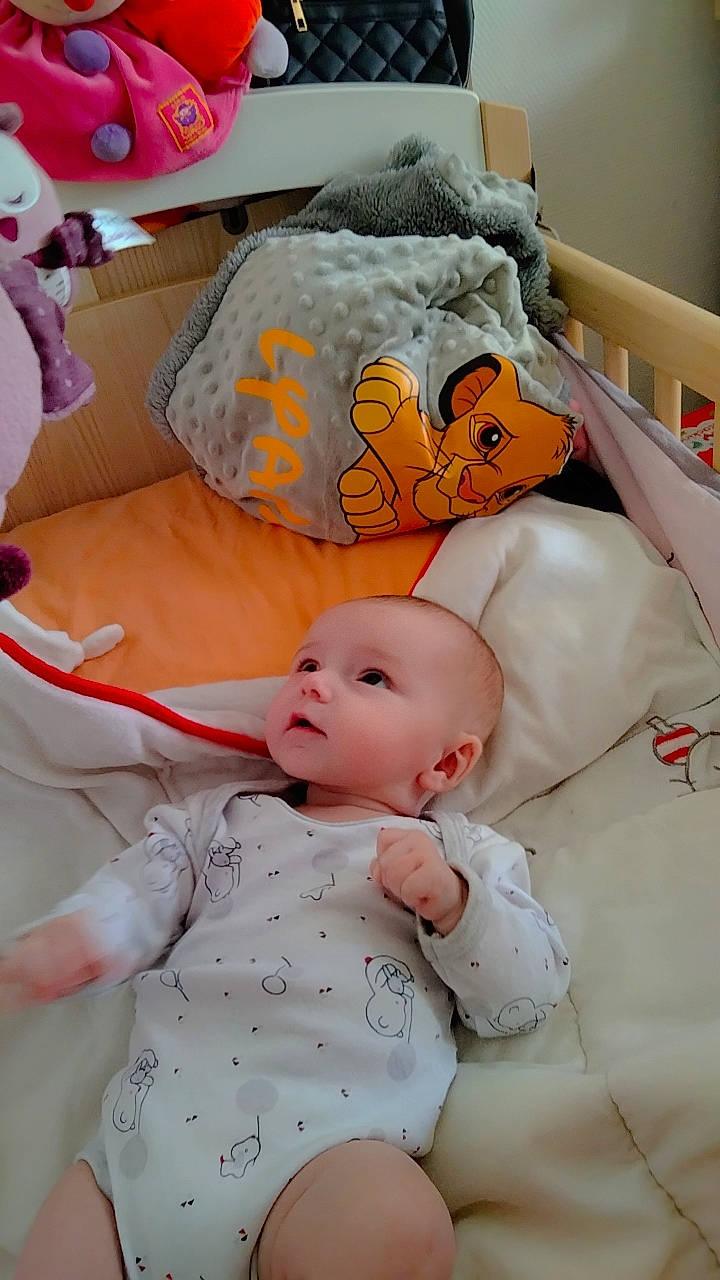 Lyana participe au concours pour gagner de l'argent avec cette photo : baby, baby_products, baby_safety, baby_sleeping, baby_toddler_clothing, bed, bedding, bedtime, cheek, child, comfort, infant_bed, linens, nap, orange, person, pink, room, sitting, textile