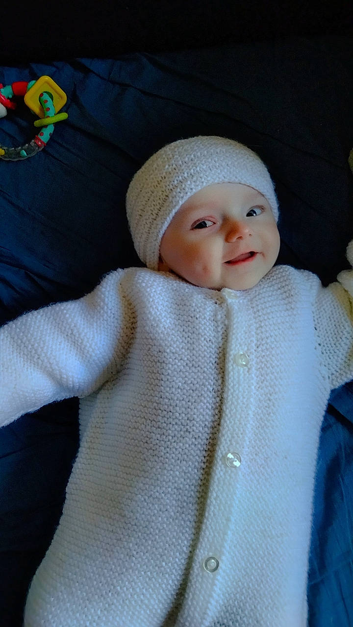 Lyana participe au concours pour gagner de l'argent avec cette photo : baby, baby_toddler_clothing, beanie, cap, cheek, child, comfort, craft, fashion_accessory, headwear, knit_cap, linens, pattern, person, product, skin, sleeve, smile, textile, toddler