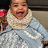 baby, smiling, happy, child, face, flower_accessories, bib, blue_clothing, floral_pattern, cute, portrait, indoor, infant, young_child, joy, dressed_up, person, closeup, cheerful, adorable