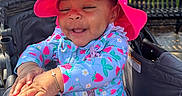Brazille joined the competition — help win amazing prizes! baby, child, stroller, pink_hat, strawberry_pattern, clothing, happy, smiling, outdoor, daylight, park, bench, tree, sunlight, skin, face, hands, infant, cute, sitting
