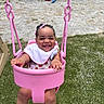 baby, child, swing, playground, pink, smile, happy, grass, outdoor, bib, hair_clips, footwear, fence, toy, sunny, toddler, seat, joyful, person, summer