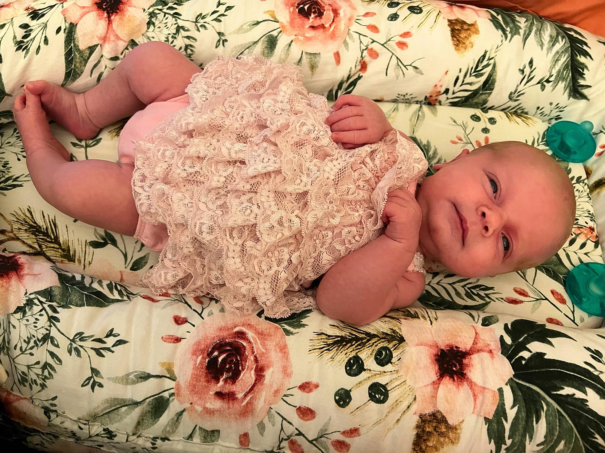 Baylor is registered to the contest to win money with this photo: baby, baby_products, baby_sleeping, baby_toddler_clothing, bedding, child, comfort, cut_flowers, embellishment, fashion_accessory, floral_design, linens, pattern, peach, person, petal, pink, room, tableware, textile