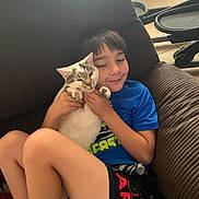 Jack N Jill joined the competition — help win amazing prizes! boy, cat, couch, indoor, child, pet, smile, happy, casual_clothing, legs, furniture, floor, tiled_floor, holding, relaxing, brown_couch, shorts, blue_shirt, domestic_animal, affection