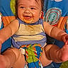 baby, child, infant, smiling, happy, portrait, seated, activity_seat, play_mat, colorful, indoor, toy, butterfly, clouds, baby_clothing, bib, messy_face, dark_hair, reaching, family_photo