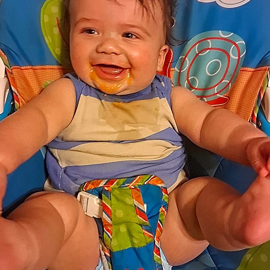 Oliver joined the competition — help win amazing prizes! baby, child, infant, smiling, happy, portrait, seated, activity_seat, play_mat, colorful, indoor, toy, butterfly, clouds, baby_clothing, bib, messy_face, dark_hair, reaching, family_photo