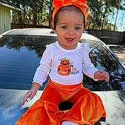 Ta'Leya joined the competition — help win amazing prizes! toddler, child, baby, orange_headband, orange_pants, white_shirt, halloween, pumpkin_design, outdoor, car, sunny, trees, smiling, sitting, happy, daylight, headband, pants, baby_clothes, portrait