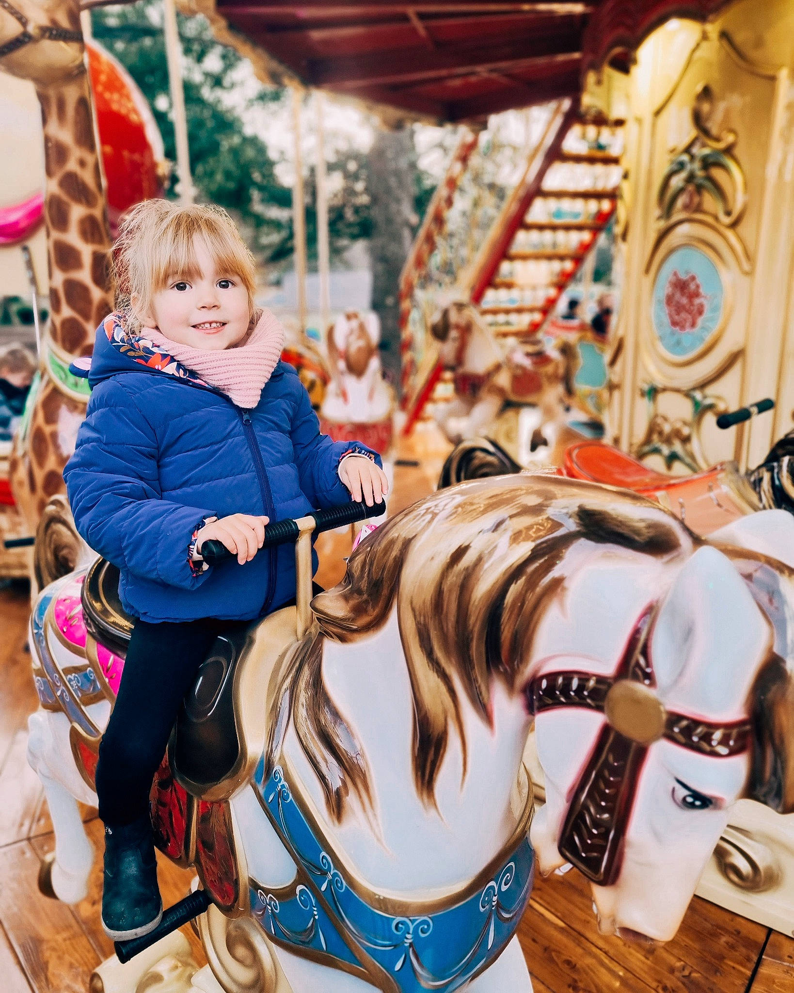Anna participe au concours pour gagner de l'argent avec cette photo : amusement_park, amusement_ride, carousel, child, city, event, fair, fashion_design, fun, happy, horse_tack, joy, leisure, nonbuilding_structure, person, photograph, recreation, smile, thigh, toddler