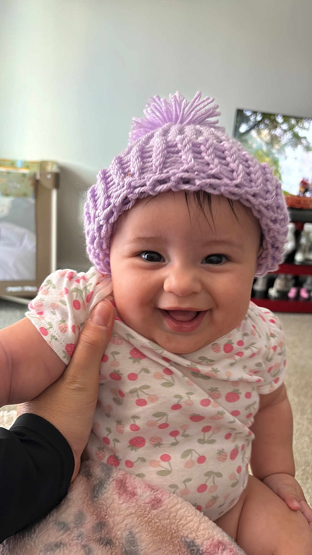 Anyelina Antonella is registered to the contest to win money with this photo: baby, child, smile, happy, hat, knitted_hat, onesie, cherry_pattern, hand, blanket, indoor, carpet, person, face, cute, infant, portrait, warm, cozy, home