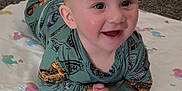 Creed joined the competition — help win amazing prizes! baby, child, smiling, pajamas, blanket, indoor, cute, infant, face, hands, happy, lying_down, expression, clothing, person, toddler, skin, eyes, head, cozy