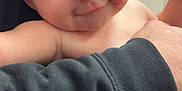 Peyton joined the competition — help win amazing prizes! baby, infant, diaper, smile, face, skin, arm, hand, adult, clothing, black_sweatshirt, holding, indoor, person, closeup, expression, cheek, red_mark, candid, playful