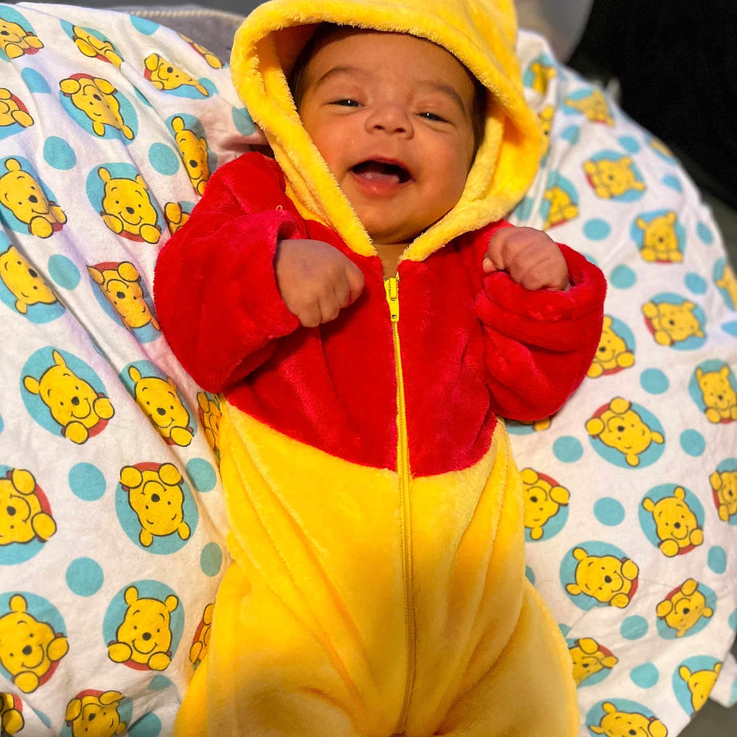 Messiah joined the competition — help win amazing prizes! baby, blanket, child, clothing, cozy, cute, face, happy, hood, indoors, infant, lying_down, onesie, pattern, portrait, red, smiling, soft, winnie_the_pooh, yellow