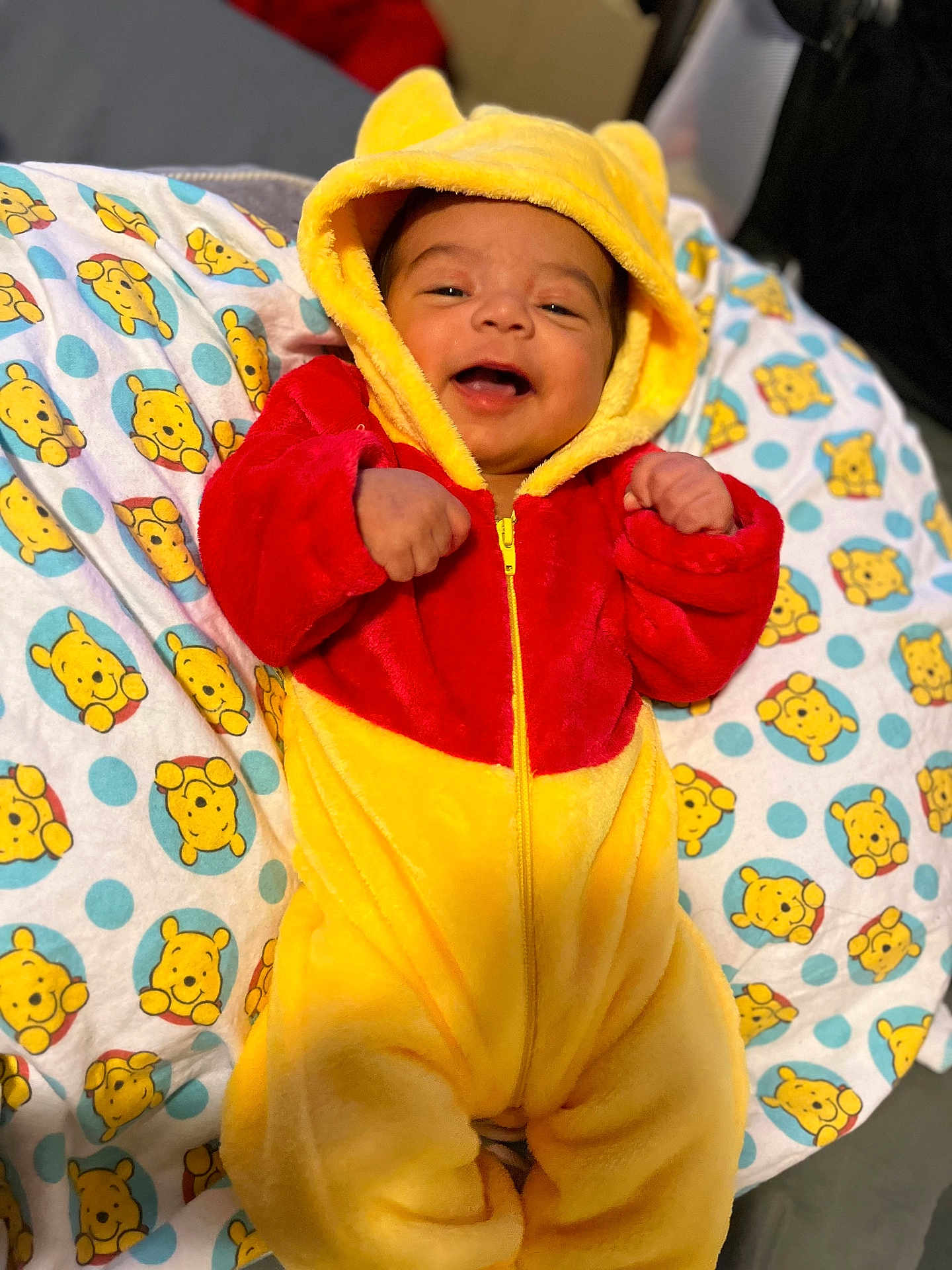 Messiah joined the competition — help win amazing prizes! baby, infant, smiling, winnie_the_pooh, onesie, hood, yellow, red, blanket, pattern, cute, happy, child, portrait, face, clothing, indoors, soft, cozy, lying_down